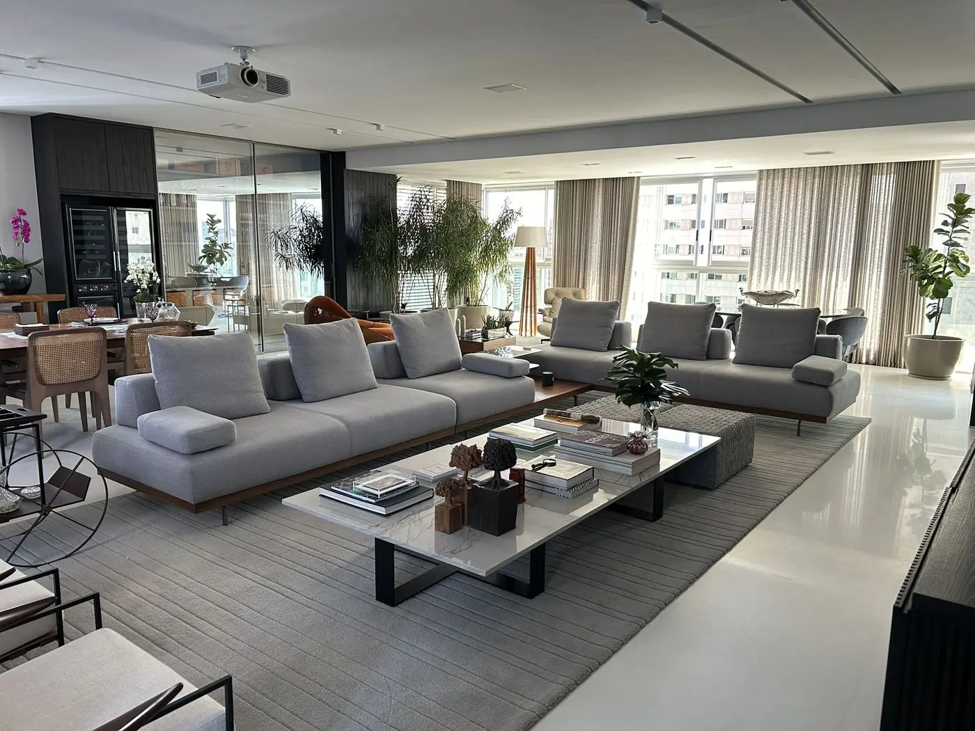 Sala ampla com sofás claros sobre tapete
